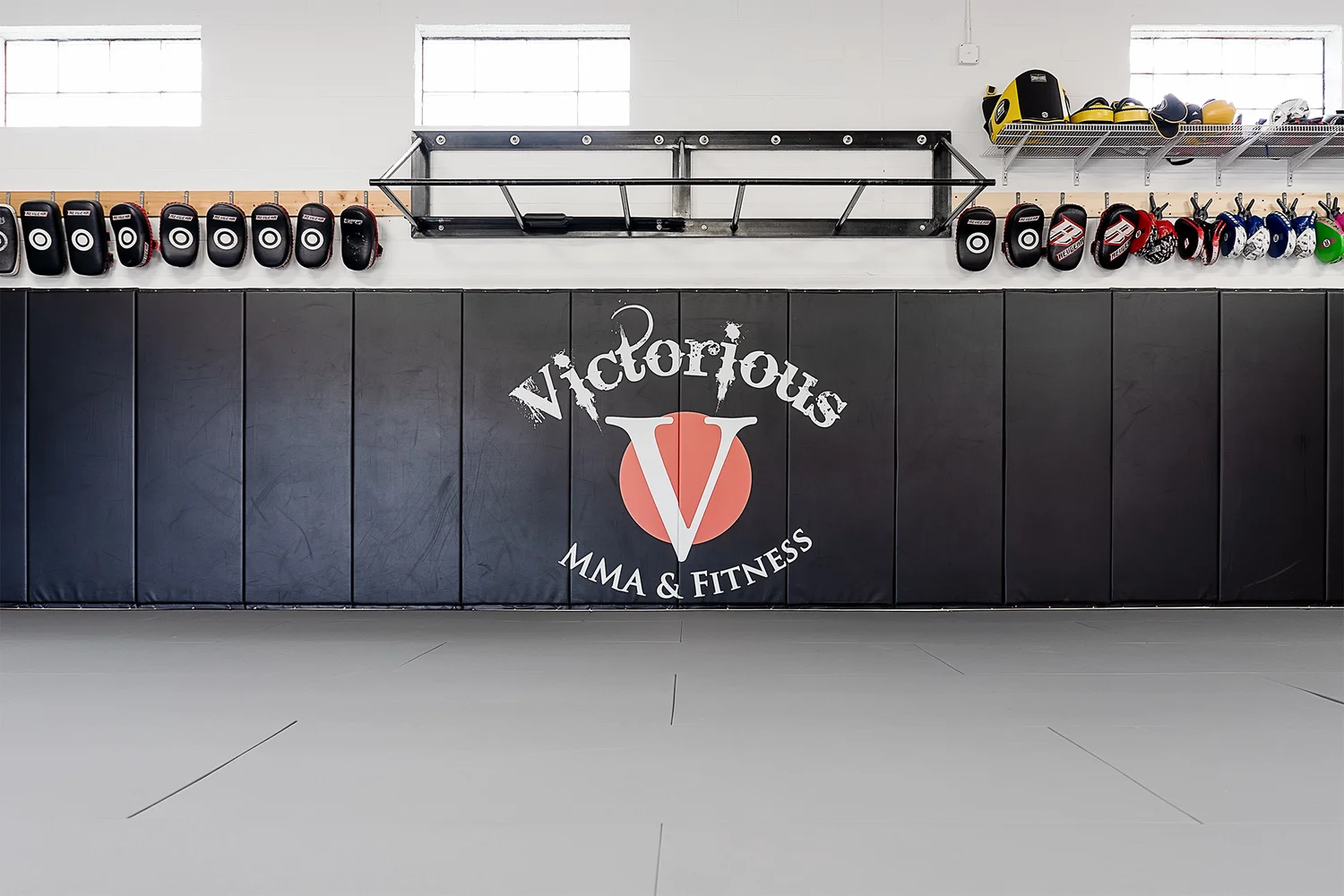 Victorious MMA logo wall — black wall pads with the Victorious MMA V logo in Troy, Michigan