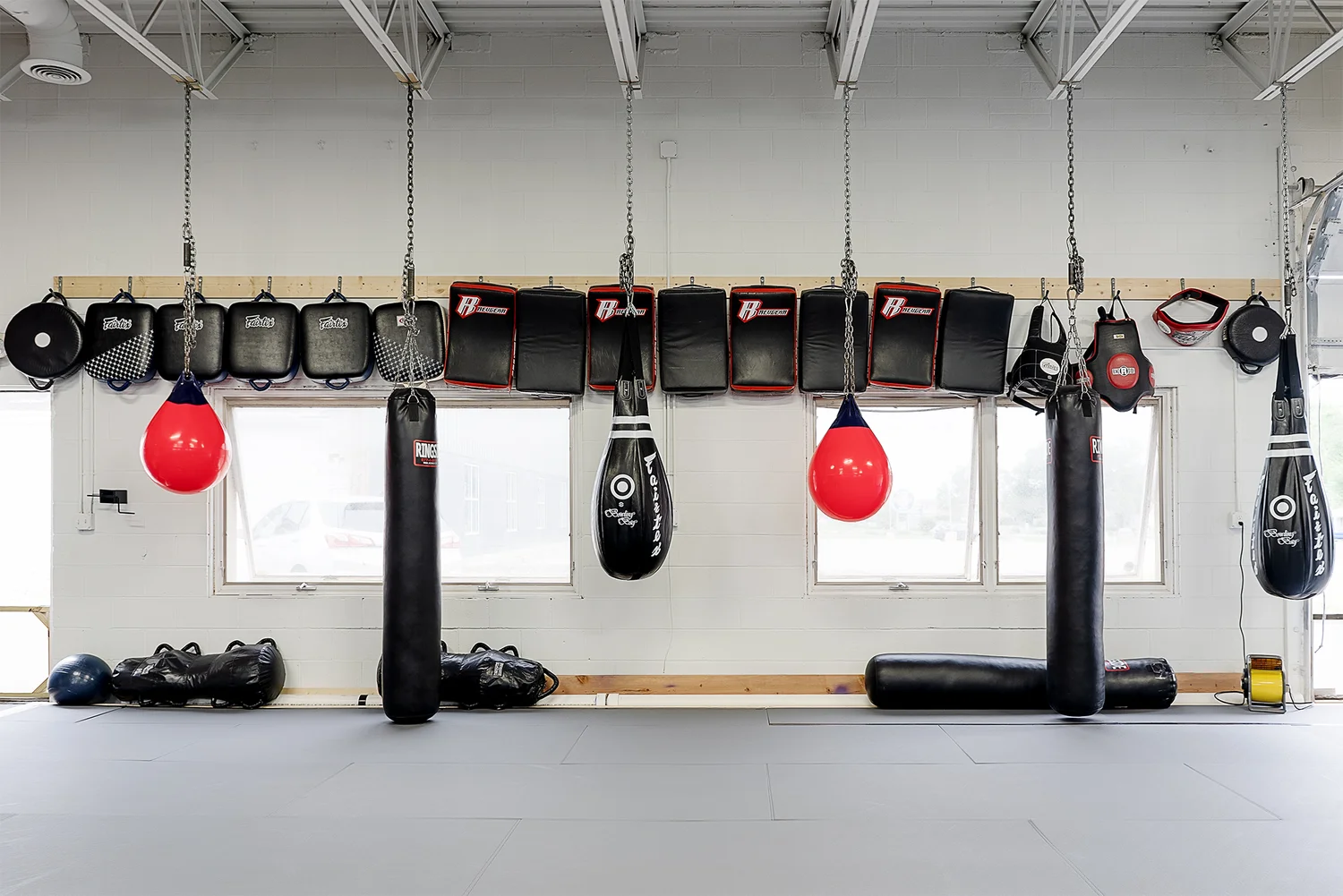 Striking area at Victorious MMA — heavy bags, speed bags, and punching bags hanging from the ceiling