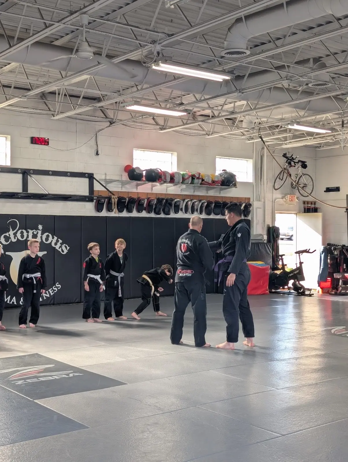 Kids BJJ class lined up in formation as instructors lead training at Victorious MMA Troy Michigan