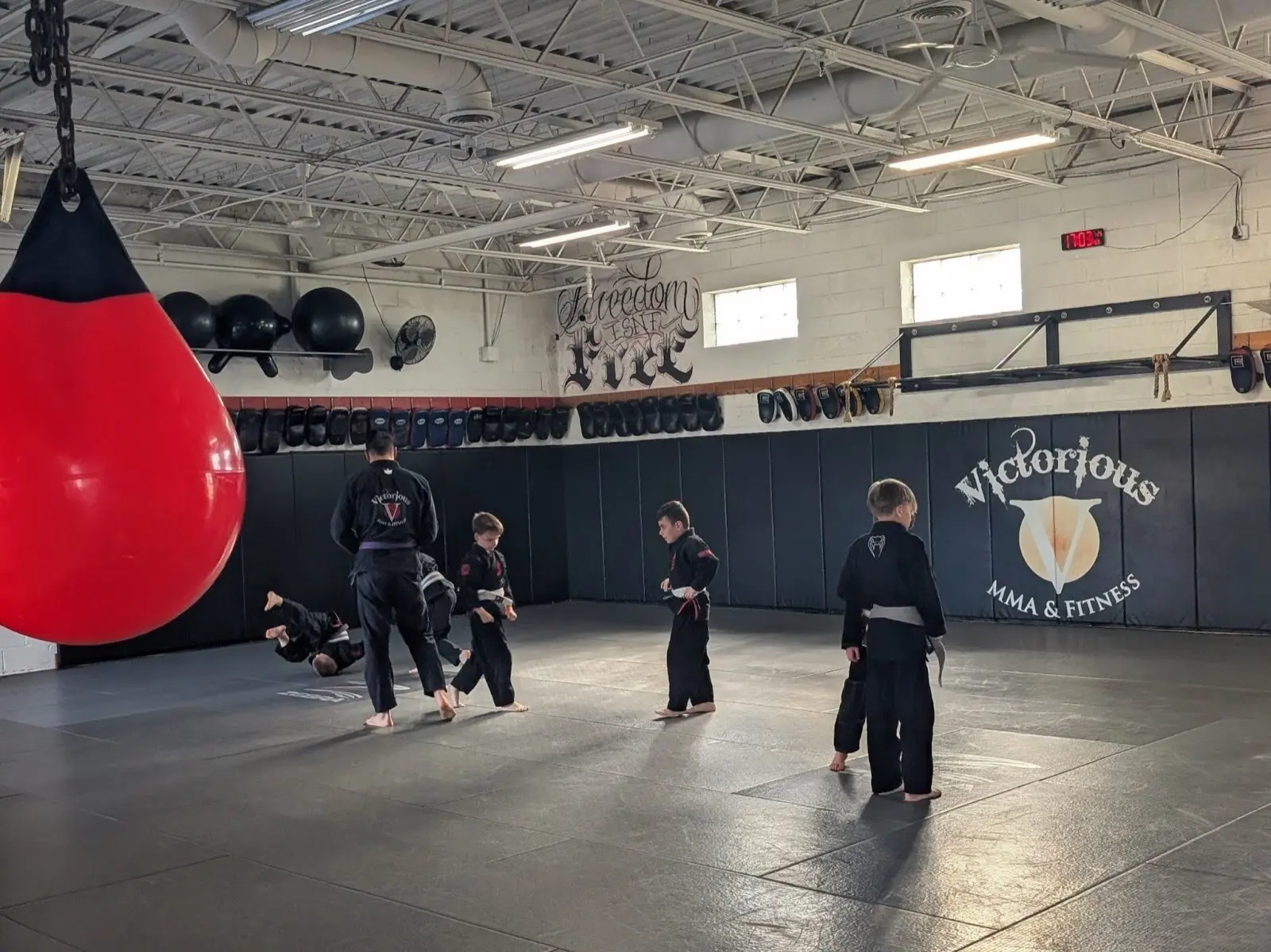 Kids BJJ students practicing technique under instructor supervision at Victorious MMA Troy Michigan